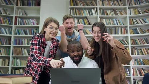 Multiethnic People which Satisfied from the Good News on Laptop Screen on the Library