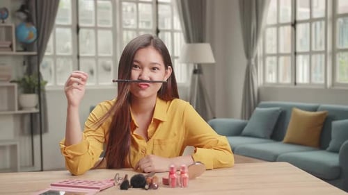 Divertida bloguera de belleza, ríe y sonríe, vídeo tutorial de maquillaje en Home Studio