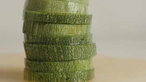Slices of Pepo cylindrica on cutting board 4K 2160p 30fps UltraHD tilting footage - Healthy zucch