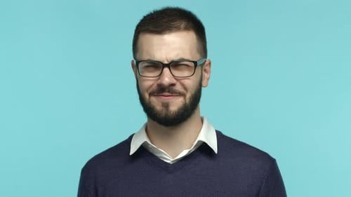 Zeitlupe eines gutaussehenden erwachsenen Mannes mit Bart, Brille, Kopfschütteln und Grimassen von