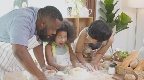 Happy Family Kneading Dough Together in Kitchen