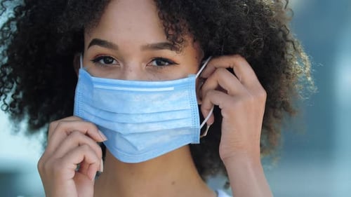 Woman Putting On a Protective Surgical Mask
