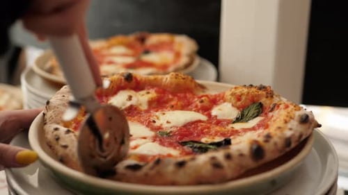 Chef in the Pizzeria Prepares a Pizza and Decorates It with Parmesan Cheese Pepper and Basil