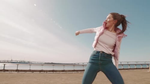Young Woman Dancing on Embankment