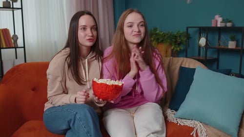 Two Women Enjoying Popcorn and Conversation at Home