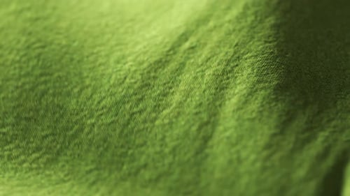 Highly detailed green cloth fabric fluttering on the wind. Surface fiber pattern