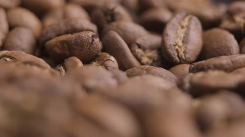 Macro close up, roasted coffee beans spinning shot. Abstract pattern