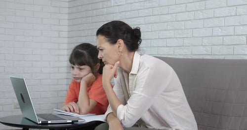 Woman and Child Typing on a Laptop