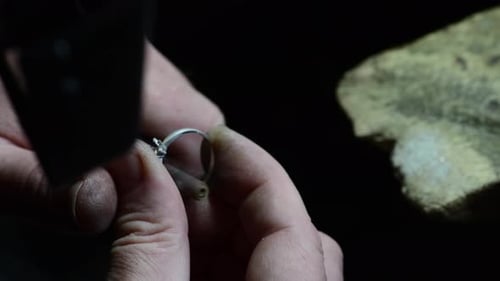 Jeweler sets gem into a ring