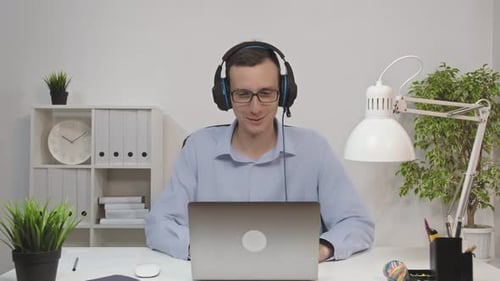 Man working on laptop with headphones