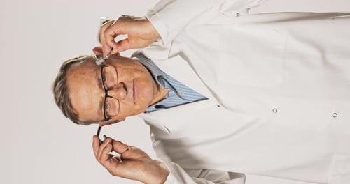 Doctor Putting Stethoscope Around Neck in Studio
