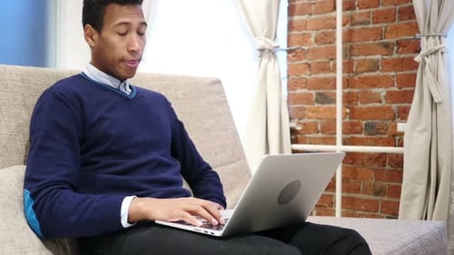 Young Adult Working on Laptop at Home