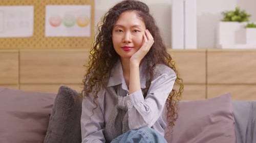 Happy Woman Smiling with Curly Hair on Couch