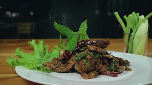 Close up cooking sliced grilled beef salad with pepper and oregano leafs.