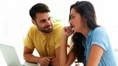 Young Couple Using Laptop in Bright Indoor Room