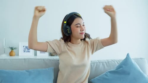 Woman Listening to Music and Dancing on Couch
