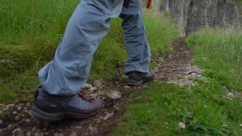 A hiker is hiking on a mountain trail.