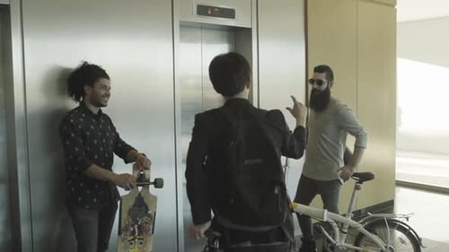 Adults Waiting for Elevator with Bike and Skateboard