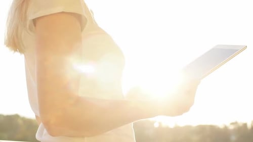 Woman Uses Tablet in Bright Sunlight
