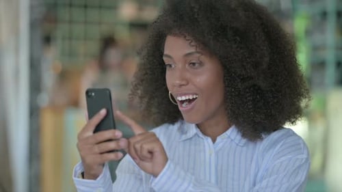 Smiling Woman Using Smartphone Indoors