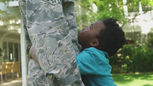 Child Hugging Military Member on Sunny Day