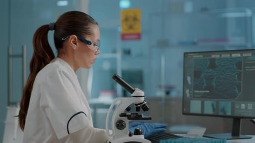 Woman Scientist Using Microscope in Modern Lab