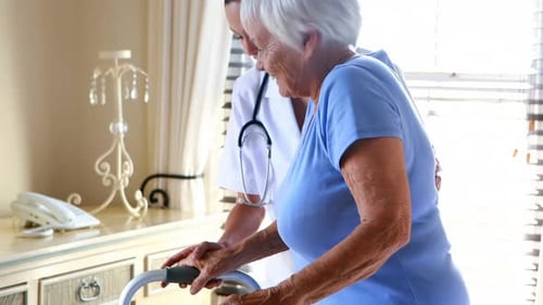 Female doctor helping senior woman to walk with a walker