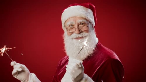 Santa Claus Holds Sparklers Against a Red Background