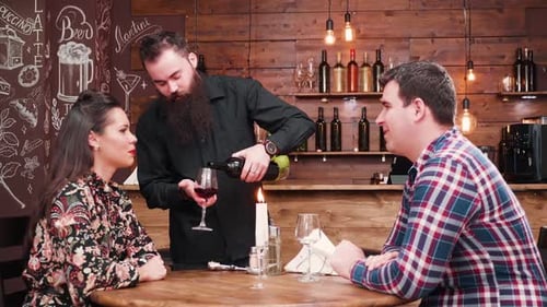Bartender Pouring Red Wine for Happy Couple
