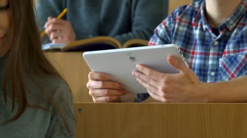 Un étudiant montre quelque chose à son camarade de classe sur la tablette