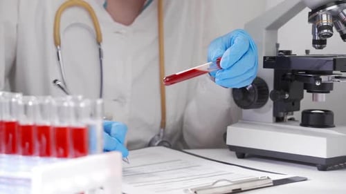 Der Arzt untersucht den Bluttest des Patienten und schreibt die Ergebnisse auf ein Formular. Modernes Labor