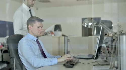 Two Mature Businessmen Discussing Document on Office Table