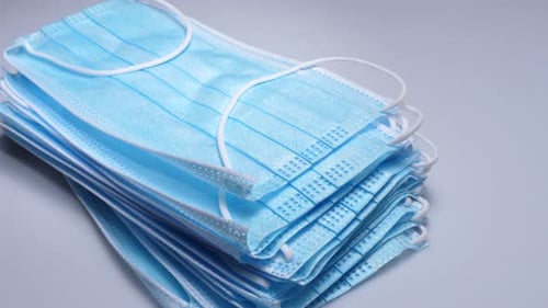Close Up of Stacked Light Blue Surgical Masks