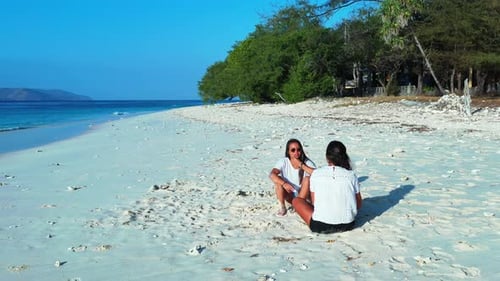 Sexy smiling ladies travelling spending quality time on beach on summer white sandy and blue 4K back