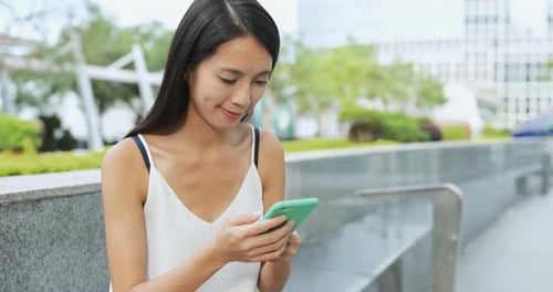 Woman looking at mobile phone in the city