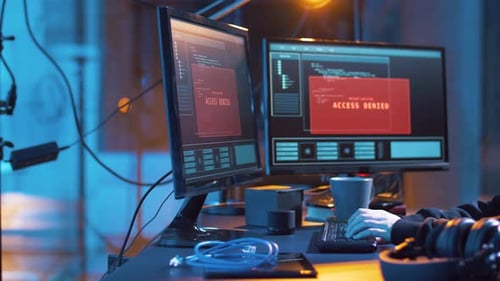 Young Adult Coding at Desk in Blue Lit Room