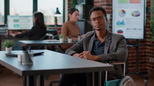 Man in Wheelchair at Desk in Modern Office