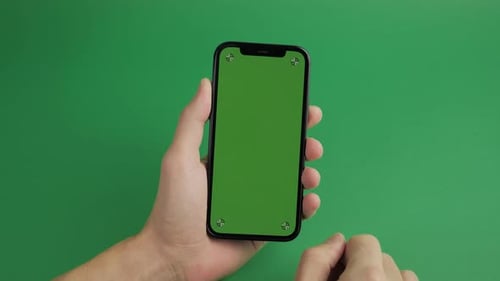 Closeup of Male Hand Holding Mobile Telephone with Vertical Green Screen Chroma Key Smartphone