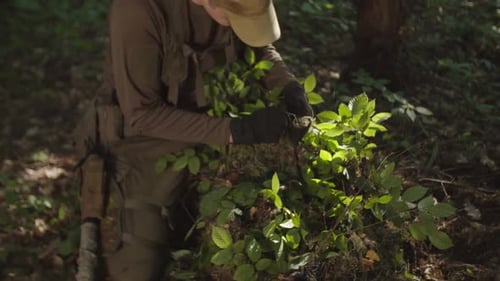 Young Soldier Preparing Tactical Sniper Camouflage Clothing in Forest