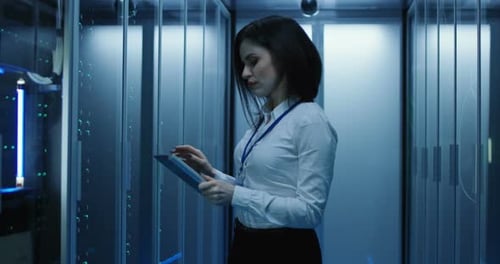 Female Technician Works on a Tablet in a Data Center