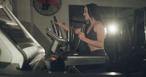 Cheerful Woman Smiling While Working Out on Steppers in a Gym