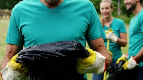 Volunteer holding a disposable bag in park