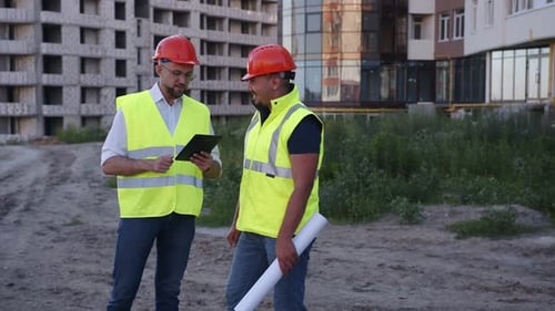 Two Builders Stand and Talk to Each Other