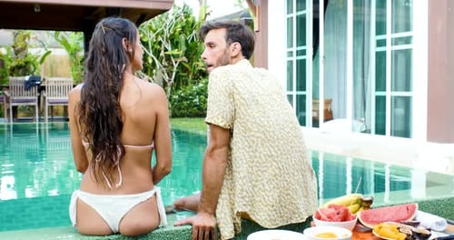 Romantic Couple Kissing Poolside at Tropical Villa