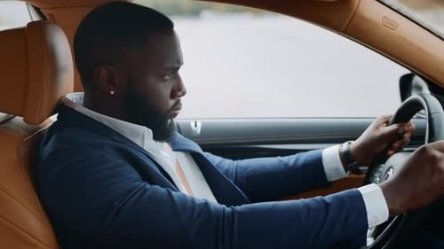 Side View of Afro Man Driving Alone at Car. African Man Riding at Modern Vehicle