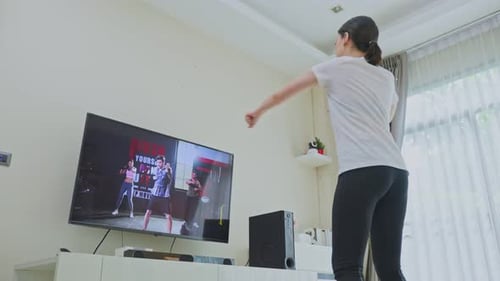 Hermosa joven asiática que se queda en casa, haciendo ejercicio, siga las instrucciones del vídeo del entrenador en línea.