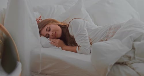 Young Woman Sleeping and Waking Up in Bed