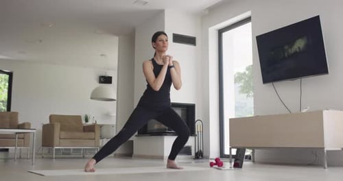 Woman Doing Lunges on a Mat in her Home