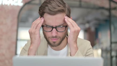 Close Up of Man with Laptop Having Headache