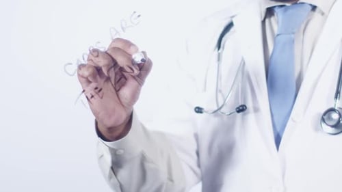 Doctor Writing Carbs are the Enemy on Glass